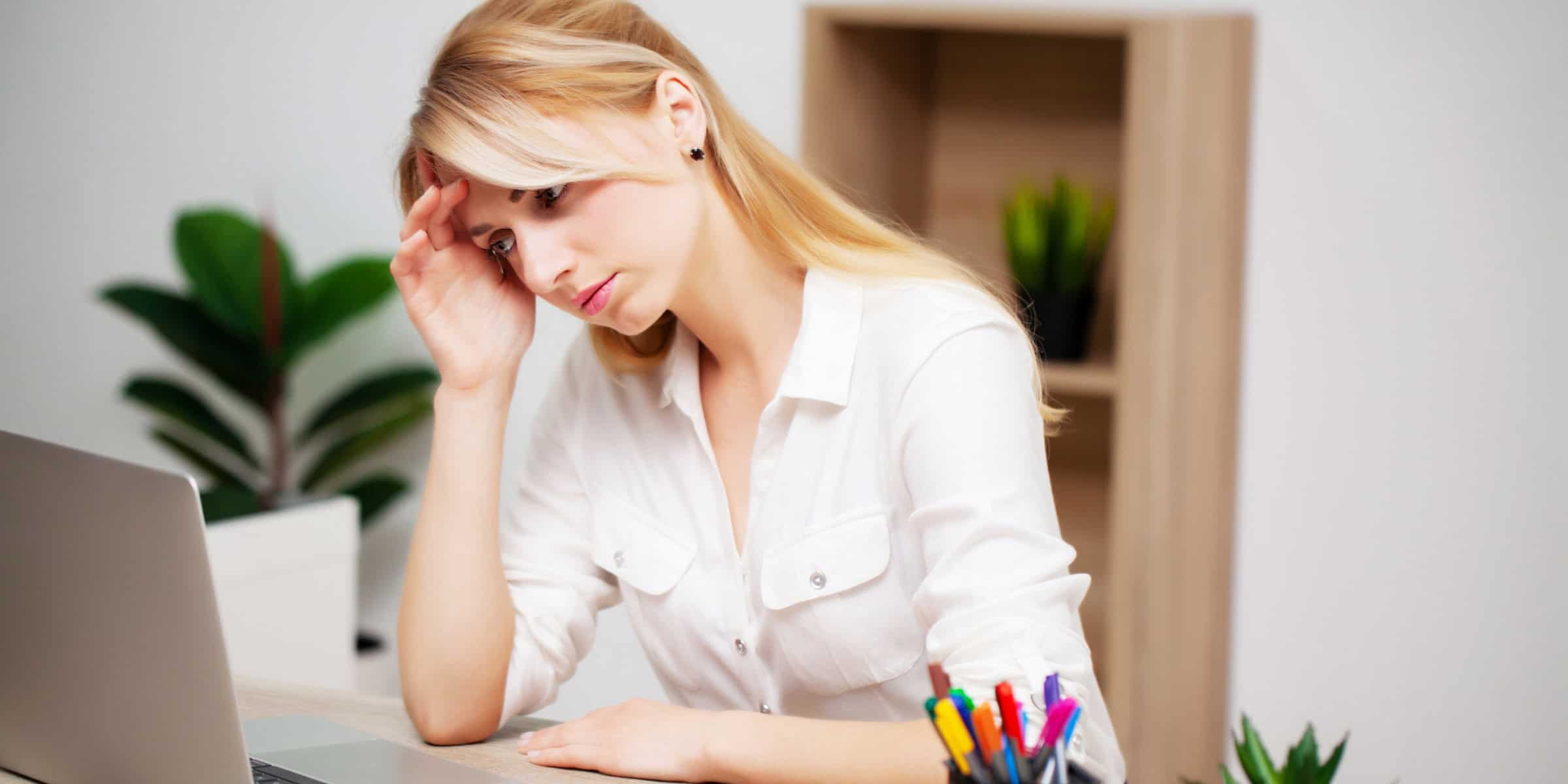 A woman is sitting at a desk with a laptop.