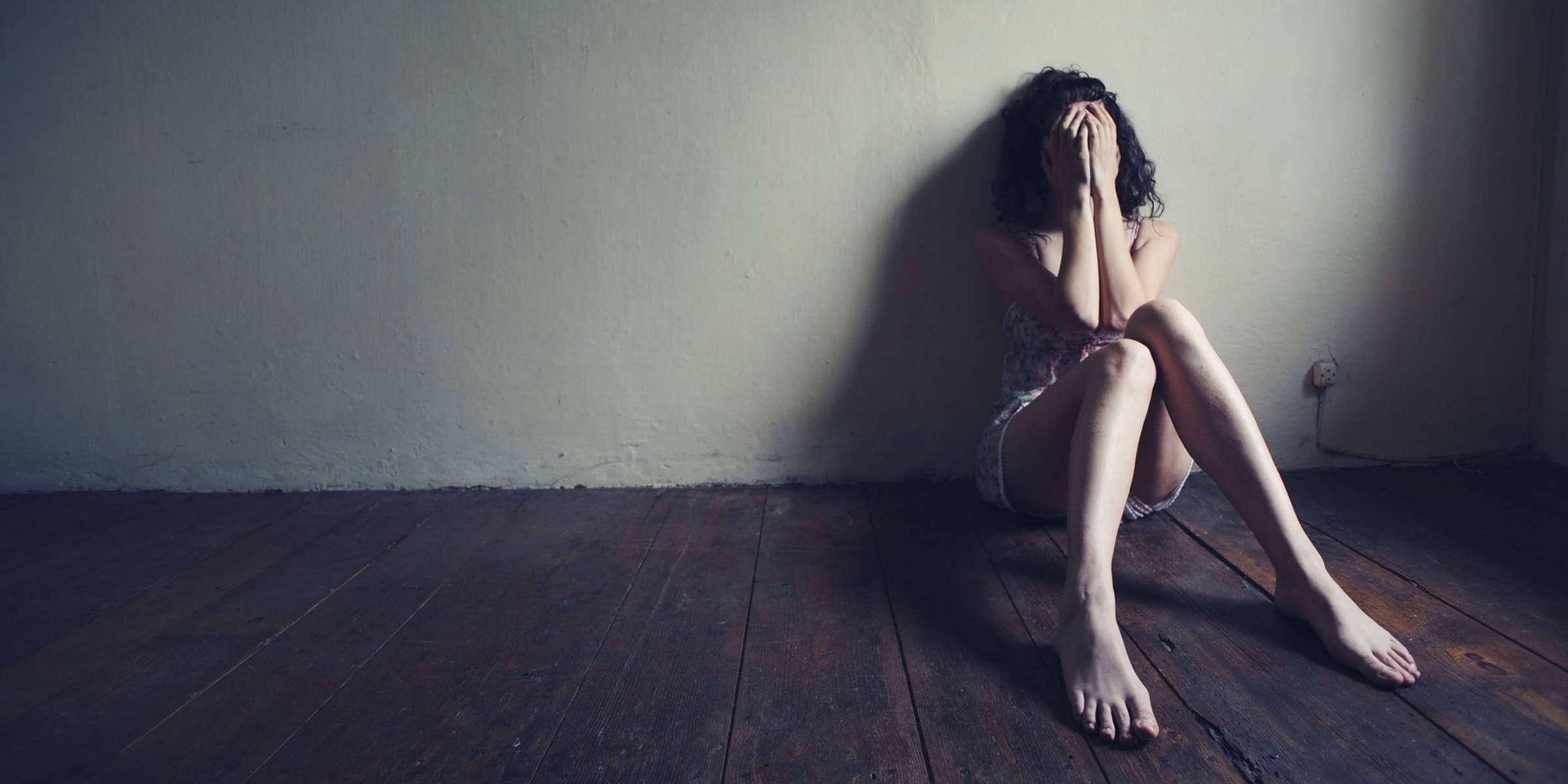depressed woman sat on floor